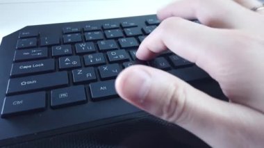PC klavyesinde erkek eller, yakın çekim, adam hızlı bir şekilde metin yazar. Bilgisayarda ofis ya da ev işi kavramı.