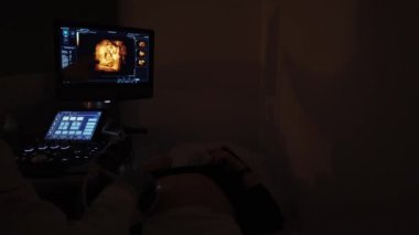 Doktor hamile bir kızla ultrason yapıyor.