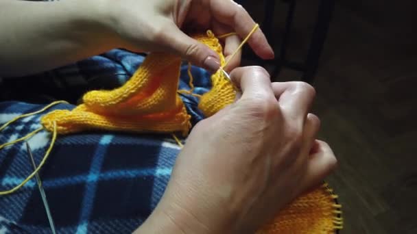 女性の手は編み物の針とウールのジャケットを編んだ トップビュー 手と編み物のクローズアップ — ストック動画