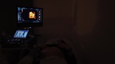 Doktor hamile bir kızla ultrason yapıyor..