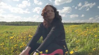 Kız çiçek açan karahindibalarla kaplanmış bir çayırda oturuyor. Bir kadın portresi bir buket sarı çiçek seçer. Bir tarlada karahindiba çiçeği..