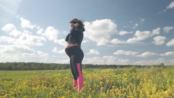Беременная Девушка Цветущем Поле Занимается Спортом — стоковое видео