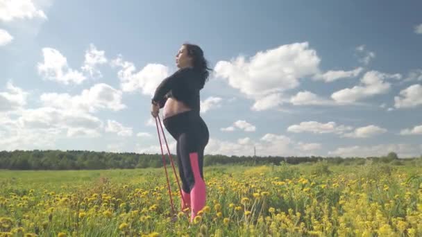 Беременная Девушка Цветущем Поле Занимается Спортом — стоковое видео