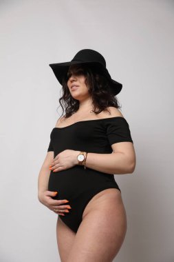 Stüdyoda poz veren güzel hamile bir kadın.