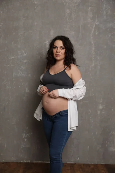 Stüdyoda poz veren güzel hamile bir kadın.