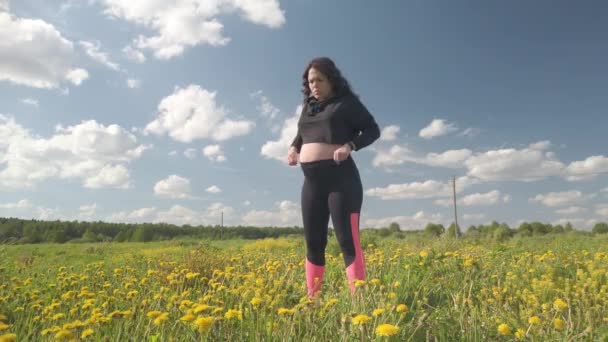 Беременная девушка отдыхает в поле с красивыми желтыми цветами — стоковое видео