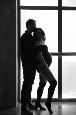 Güzel, mutlu bir çift bebek bekliyor. Bir fotoğraf stüdyosunda çocuk bekleyen evli bir çift..