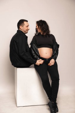 Güzel, mutlu bir çift bebek bekliyor. Bir fotoğraf stüdyosunda çocuk bekleyen evli bir çift..