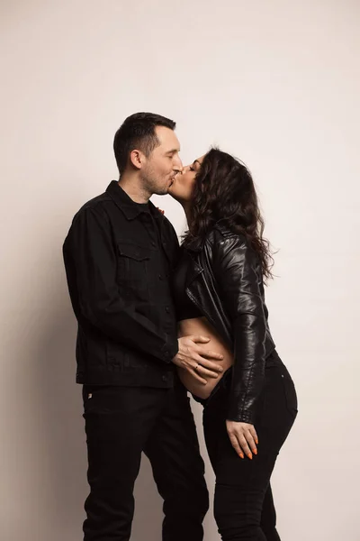 Güzel, mutlu bir çift bebek bekliyor. Bir fotoğraf stüdyosunda çocuk bekleyen evli bir çift..