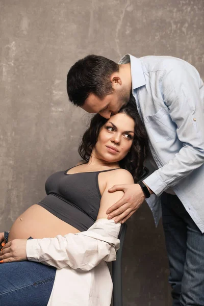 Güzel, mutlu bir çift bebek bekliyor. Bir fotoğraf stüdyosunda çocuk bekleyen evli bir çift..