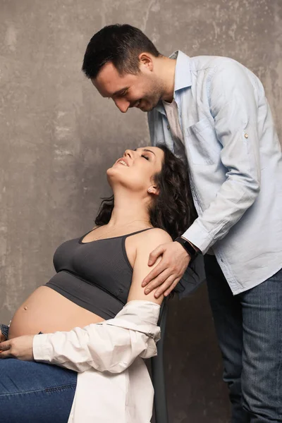 Güzel, mutlu bir çift bebek bekliyor. Bir fotoğraf stüdyosunda çocuk bekleyen evli bir çift..