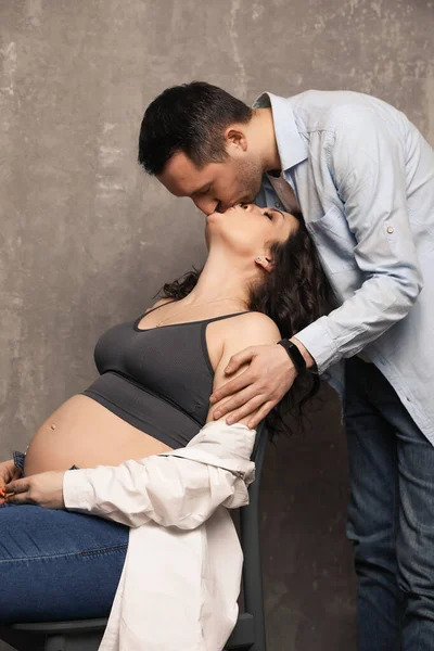 Güzel, mutlu bir çift bebek bekliyor. Bir fotoğraf stüdyosunda çocuk bekleyen evli bir çift..