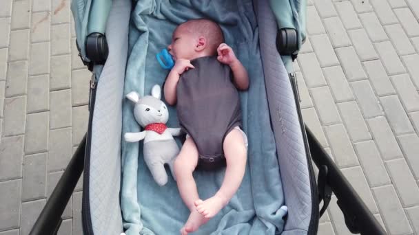 Pasgeboren Baby Liggend Een Kinderwagen Zuigen Aan Een Fopspeen Een — Stockvideo