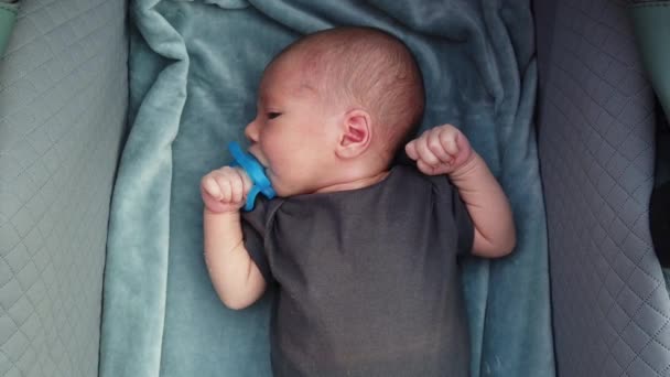 Bebê Recém Nascido Deitado Uma Carruagem Bebê Chupando Uma Chupeta — Vídeo de Stock
