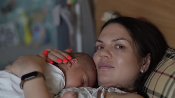 婴儿躺在母亲的胸前 母亲和孩子在家里躺在床上休息 — 图库视频影像