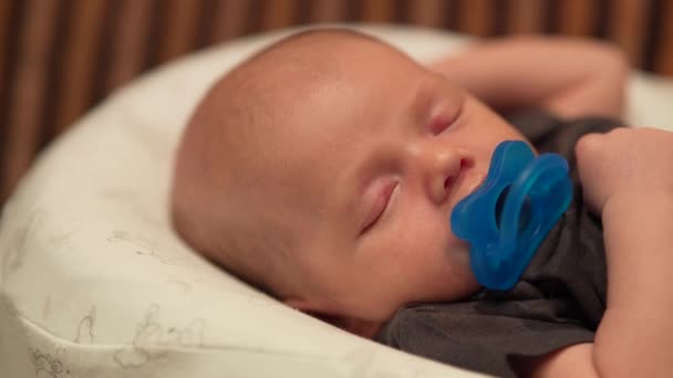 Carino bella poco bambino ragazzo dormire con un ciuccio su bianco bozzolo. — Video Stock
