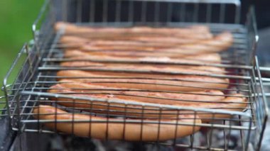 Dışarıdaki ızgarada barbekü pişirmek. Izgarada lezzetli sosisler..