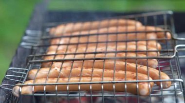 Dışarıdaki ızgarada barbekü pişirmek. Izgarada lezzetli sosisler..