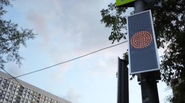 Şehirdeki trafik ışığı yüzünden. Yeşilden kırmızıya dönüşür, şehir manzarası. Şehir caddesinde çalışan bir trafik ışığı..