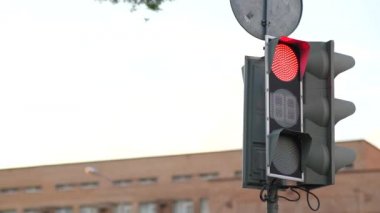 Şehirdeki trafik ışığı yüzünden. Yeşilden kırmızıya dönüşür, şehir manzarası. Şehir caddesinde çalışan bir trafik ışığı..