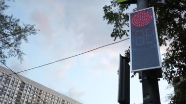 Şehirdeki trafik ışığı yüzünden. Yeşilden kırmızıya dönüşür, şehir manzarası. Şehir caddesinde çalışan bir trafik ışığı..