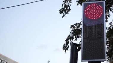 Şehirdeki trafik ışığı yüzünden. Yeşilden kırmızıya dönüşür, şehir manzarası. Şehir caddesinde çalışan bir trafik ışığı..