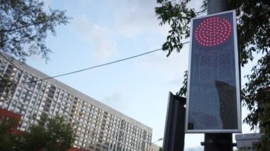 Şehirdeki trafik ışığı yüzünden. Yeşilden kırmızıya dönüşür, şehir manzarası. Şehir caddesinde çalışan bir trafik ışığı..