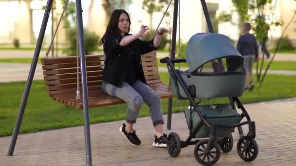 Mamma Med Barnvagn Sitter Gunga Gårdsplanen Ett Bostadshus — Stockvideo