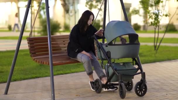 Mamma Med Barnvagn Sitter Gunga Gårdsplanen Ett Bostadshus — Stockvideo