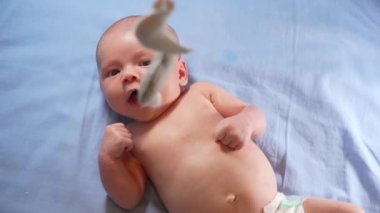 Çocuk, bebek beşiğinin üzerinde dönen el yapımı yumuşak oyuncaklarla müzikal bebek hareketine bakıyor..