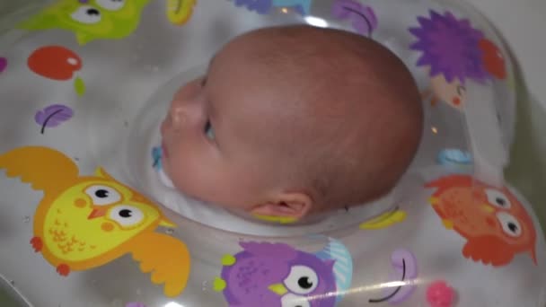 一个孩子正在浴缸里洗澡 浴缸里有一个充气圆圈 一个小孩在浴室里游泳 — 图库视频影像