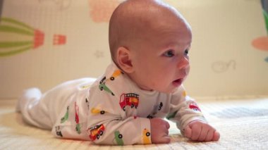 Bebek kafasını kontrol etmeyi öğreniyor, 2 aylık erkek bebek evde karnının üzerinde oyun minderinin üzerine yatarak başını kaldırıyor..