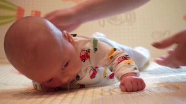 Bebek kafasını kontrol etmeyi öğreniyor, 2 aylık erkek bebek evde karnının üzerinde oyun minderinin üzerine yatarak başını kaldırıyor..