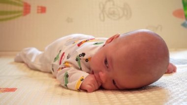 Bebek kafasını kontrol etmeyi öğreniyor, 2 aylık erkek bebek evde karnının üzerinde oyun minderinin üzerine yatarak başını kaldırıyor..