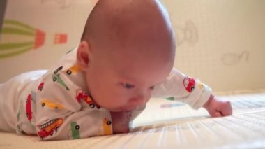 Bebek kafasını kontrol etmeyi öğreniyor, 2 aylık erkek bebek evde karnının üzerinde oyun minderinin üzerine yatarak başını kaldırıyor..
