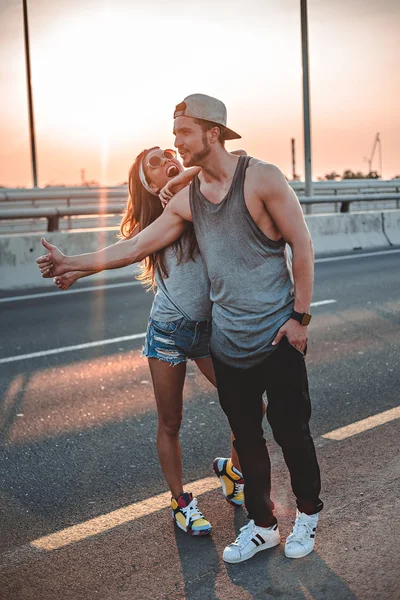 Pareja autoestop en el camino — Foto de Stock