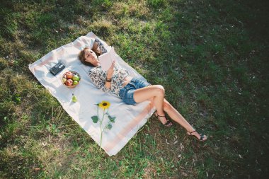 Çim üzerinde yalan ve kitap okuma kız