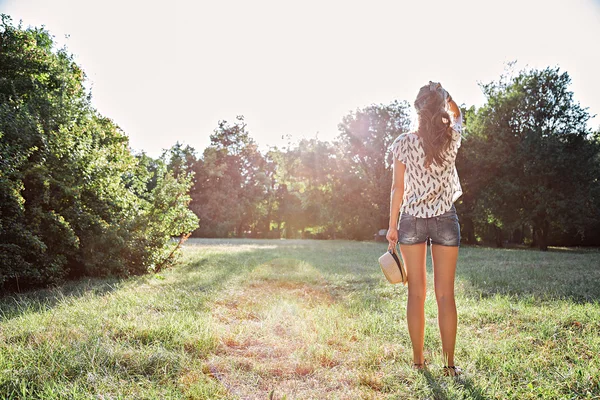 Dziewczyna w parku, patrząc w słońce — Zdjęcie stockowe