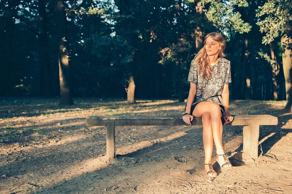 Chica sentada en un banco del parque —  Fotos de Stock