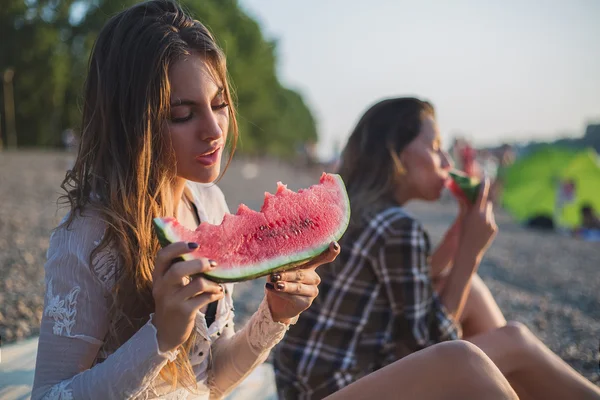 Přítelkyně jíst meloun na pláži — Stock fotografie