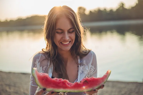 Girl eating watermelon and smiling. Sunset — Stock Photo, Image