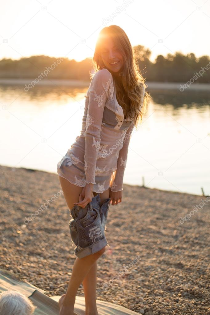 Girl putting on clothes at the beach Stock Photo sasamihajlovic 106595332