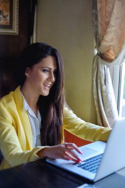 Dizüstü bilgisayar kullanırken gülüyor işkadını