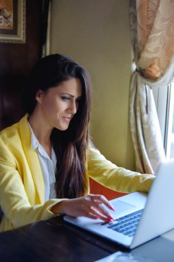 Dizüstü bilgisayar kullanırken gülümseyen iş kadını