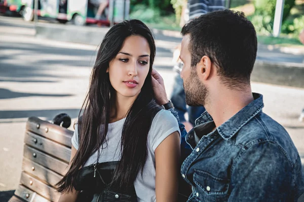 Pareja sentada en un banco del parque mirándose —  Fotos de Stock