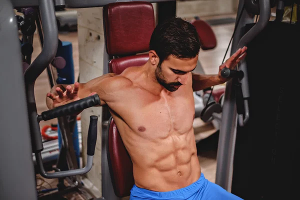 Man training on the chest machine — Stock Photo, Image