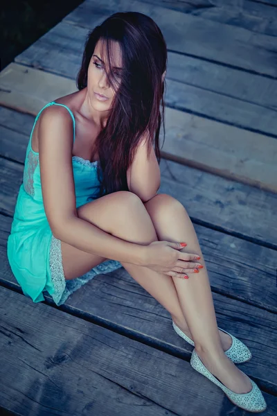 Sad girl sitting on the pier and thinking — Stock Photo, Image