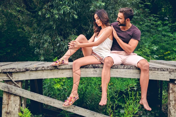 Serious couple sitting on the pier — Stock Photo, Image