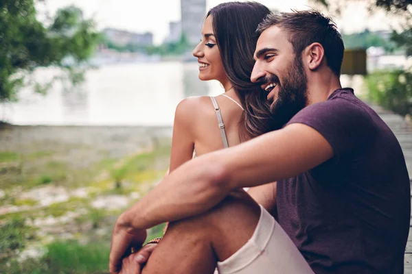 Couple assis sur la jetée et riant — Photo