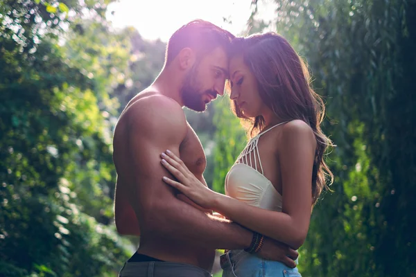 Coppia che si tiene l'un l'altro nel parco sensualmente — Foto Stock